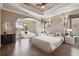 Digitally staged primary bedroom features tray ceilings, hardwood floors, and backyard views at 2605 59Th S St, Gulfport, FL 33707