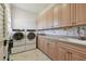 Bright laundry room with built-in cabinets, tile flooring, and modern washer and dryer at 2605 59Th S St, Gulfport, FL 33707