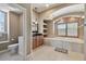 Bathroom featuring a large tub with wood shutters, vanity with framed mirror, built in shelving, and toilet at 2605 59Th S St, Gulfport, FL 33707
