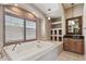 Bathroom featuring a large tub with wood shutters, vanity with a framed mirror, and built in shelving at 2605 59Th S St, Gulfport, FL 33707