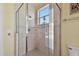 This bathroom features a large glass shower with beige tile and a window at 2605 59Th S St, Gulfport, FL 33707