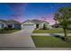 Charming single-story home featuring a well-manicured lawn and a two car garage with a beautiful twilight sky at 2805 Gumbo Limbo Dr, Wimauma, FL 33598