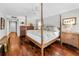 Spacious bedroom features a four-poster bed, hardwood floors and neutral decor at 2950 Meadow Hill Dr, Clearwater, FL 33761