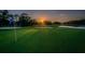 Scenic golf course view with a lush green field and a vibrant blue sky, with trees, sand trap, and water in the background at 2950 Meadow Hill Dr, Clearwater, FL 33761