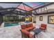 Backyard at dusk featuring an outdoor kitchen, pool, and ample seating area at 3100 Barbour Trl, Odessa, FL 33556