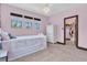 Charming pink bedroom featuring three windows, chandelier and a glimpse into a walk-in closet at 3100 Barbour Trl, Odessa, FL 33556