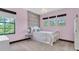 Charming pink bedroom with accent wall, three windows, and a whimsical chandelier at 3100 Barbour Trl, Odessa, FL 33556