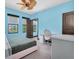 Stylish blue bedroom featuring a ceiling fan, desk, and natural light from windows at 3100 Barbour Trl, Odessa, FL 33556