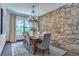 Elegant dining room featuring a stone accent wall, chandelier, and natural light from the large window at 3100 Barbour Trl, Odessa, FL 33556