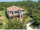 Elegant two-story home featuring a terracotta tile roof, manicured landscaping, and a welcoming arched entryway at 3100 Barbour Trl, Odessa, FL 33556