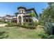 Elegant two-story home showcasing manicured landscaping, an arched entryway, and a terracotta tile roof at 3100 Barbour Trl, Odessa, FL 33556