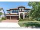 Elegant two-story home with a barrel tile roof, arched entryway, and a three-car garage at 3100 Barbour Trl, Odessa, FL 33556