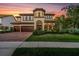 Stunning two-story home featuring a barrel tile roof, manicured landscaping, and a three-car garage at 3100 Barbour Trl, Odessa, FL 33556
