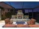 Outdoor fireplace with seating under a screened enclosure at dusk at 3100 Barbour Trl, Odessa, FL 33556