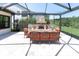 The screened-in patio showcases a stone fireplace and plush outdoor seating, creating an ideal relaxation and entertainment area at 3100 Barbour Trl, Odessa, FL 33556