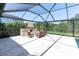 Outdoor fireplace with seating under a screened enclosure in the backyard of the home at 3100 Barbour Trl, Odessa, FL 33556