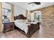 Comfortable main bedroom with a stone accent wall and wood-look tile floors at 3100 Barbour Trl, Odessa, FL 33556