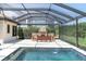 Covered outdoor living area featuring a stone fireplace and seating area by the pool at 3100 Barbour Trl, Odessa, FL 33556
