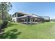 Spacious backyard featuring a screened pool area with lounge chairs and an outdoor living space at 3100 Barbour Trl, Odessa, FL 33556