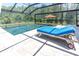 The inviting screened-in pool and patio area is complete with a comfortable chaise lounge for poolside relaxation at 3100 Barbour Trl, Odessa, FL 33556