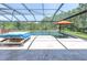 Screened-in pool area featuring a pool with water features, lounge chairs, and lush landscaping at 3100 Barbour Trl, Odessa, FL 33556