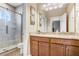Bright bathroom with granite countertop, wood cabinets, and a glass-enclosed shower at 3243 Watermark Dr, Wesley Chapel, FL 33544