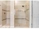 Bright bathroom featuring tiled walk-in shower with glass door and built-in bench at 3243 Watermark Dr, Wesley Chapel, FL 33544