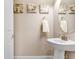 Chic powder room featuring a pedestal sink, decorative mirror, and tasteful wall art, perfect for guests at 3243 Watermark Dr, Wesley Chapel, FL 33544