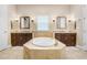 Luxurious bathroom with soaking tub, double vanities, and a neutral color palette at 3243 Watermark Dr, Wesley Chapel, FL 33544