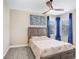 Cozy bedroom with a ceiling fan and a comfortable bed dressed with floral bedding at 3243 Watermark Dr, Wesley Chapel, FL 33544