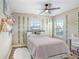Charming bedroom featuring stylish decor, two windows and ceiling fan at 3243 Watermark Dr, Wesley Chapel, FL 33544
