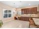 Bright kitchen area with dark wood cabinetry, breakfast nook with desk, and tile backsplash at 3243 Watermark Dr, Wesley Chapel, FL 33544