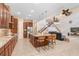 Open-concept kitchen with stainless steel appliances, granite countertops, island with seating, and staircase view at 3243 Watermark Dr, Wesley Chapel, FL 33544