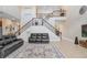 Spacious living room featuring a staircase, comfortable seating, and a stylish rug at 3243 Watermark Dr, Wesley Chapel, FL 33544