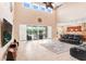 Spacious living room with high ceilings, large windows, a ceiling fan, and a view of the outdoor area at 3243 Watermark Dr, Wesley Chapel, FL 33544