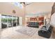 Open-concept living room with high ceilings, access to lanai, and view of the kitchen area at 3243 Watermark Dr, Wesley Chapel, FL 33544