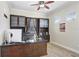 Bright home office with custom built-ins, hardwood floors, and a ceiling fan at 3243 Watermark Dr, Wesley Chapel, FL 33544