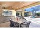 Outdoor kitchen and dining area with stone facade and stainless appliances overlooking pool at 3243 Watermark Dr, Wesley Chapel, FL 33544