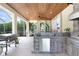 Outdoor kitchen featuring stone counters, stainless steel appliances, and bar seating at 3243 Watermark Dr, Wesley Chapel, FL 33544