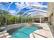 Inviting screened pool with a waterfall spa and lush landscaping creates a private oasis at 3243 Watermark Dr, Wesley Chapel, FL 33544