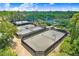 Scenic aerial shot showcasing pristine tennis courts for residents, enveloped in lush greenery and landscaping at 3243 Watermark Dr, Wesley Chapel, FL 33544