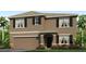 Charming two-story home featuring a two-car garage, landscaped yard, and neutral brown stucco exterior at 32674 Osprey Peak Way, San Antonio, FL 33576