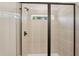 Modern bathroom with glass-enclosed shower featuring beige tile, black hardware, and a built-in window at 3269 Reservoir St, North Port, FL 34288