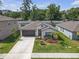 Single-story home with mature trees, manicured lawn and inviting curb appeal at 36568 Garden Wall Way, Zephyrhills, FL 33541
