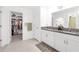 Bright bathroom featuring double sinks, a walk-in closet, and tiled flooring at 36568 Garden Wall Way, Zephyrhills, FL 33541