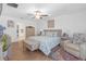 Inviting bedroom with light wood floors, a ceiling fan, a cozy chair, and decoratively patterned bedding at 36568 Garden Wall Way, Zephyrhills, FL 33541