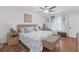 Comfortable bedroom with a plush, patterned bed, a ceiling fan, and bright window providing natural light at 36568 Garden Wall Way, Zephyrhills, FL 33541