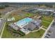 Aerial view showcasing community pool and clubhouse, plus tennis courts, playground, and parking at 36568 Garden Wall Way, Zephyrhills, FL 33541