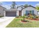 Charming single-story home with a well-manicured lawn and colorful landscaping at 36568 Garden Wall Way, Zephyrhills, FL 33541