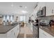 Well-lit kitchen with stainless steel appliances, white cabinetry, and adjacent dining area at 36568 Garden Wall Way, Zephyrhills, FL 33541